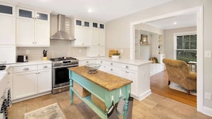 A modern kitchen with white cabinetry, a central island, stainless steel appliances, and a view to the dining area. - Charm of SouthPark - 5 Bedrooms - 1 of a Kind Lot! (Charlotte)