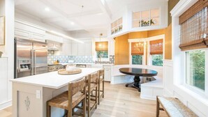 A spacious kitchen with a large island, built-in appliances, and a dining area with a round table. - The Green Monster: Indoor Slide+Bar+Near Camelback (Mount Pocono)
