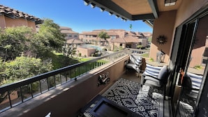 Ein Balkon mit einem gemusterten Boden, einem Stuhl und einem Tisch.