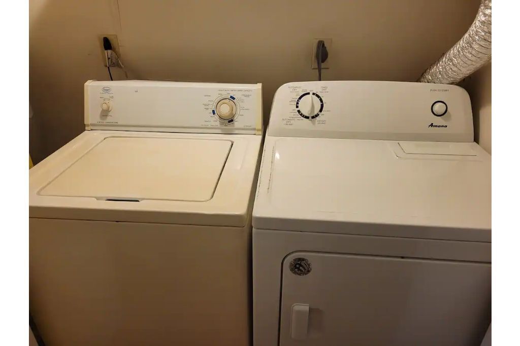 Two white front-loading washing machines side by side in a laundry room.