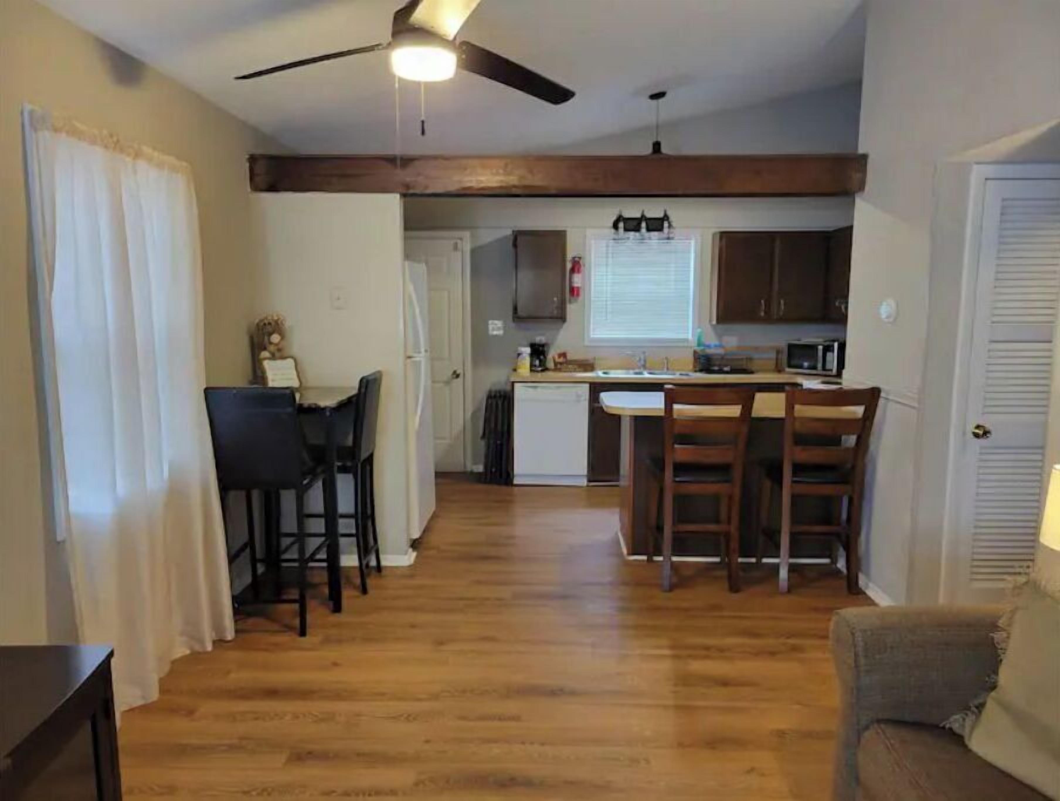 A compact living space with a dining area, kitchen, and a small seating area.