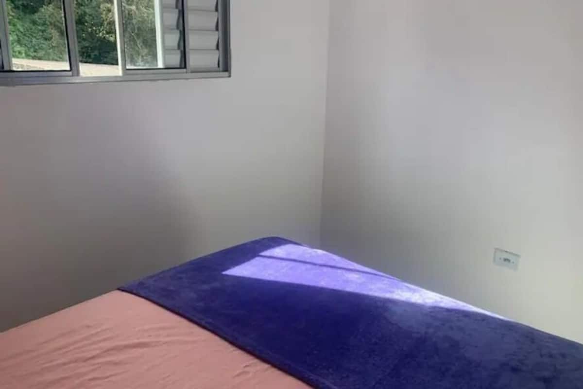 A room with a bed, a window, and a door.