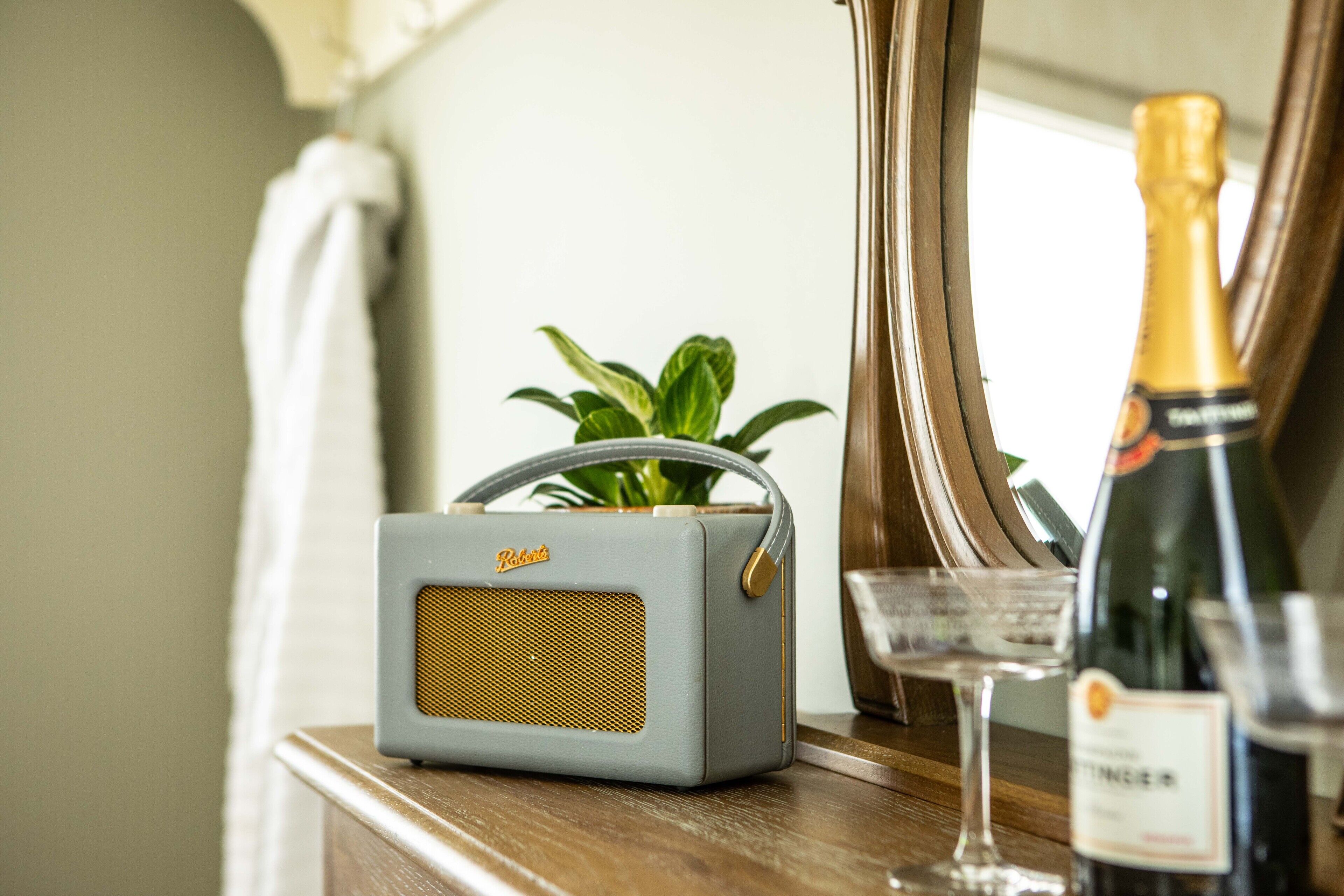 En radio, et glas champagne og en flaske vin på en træoverflade.