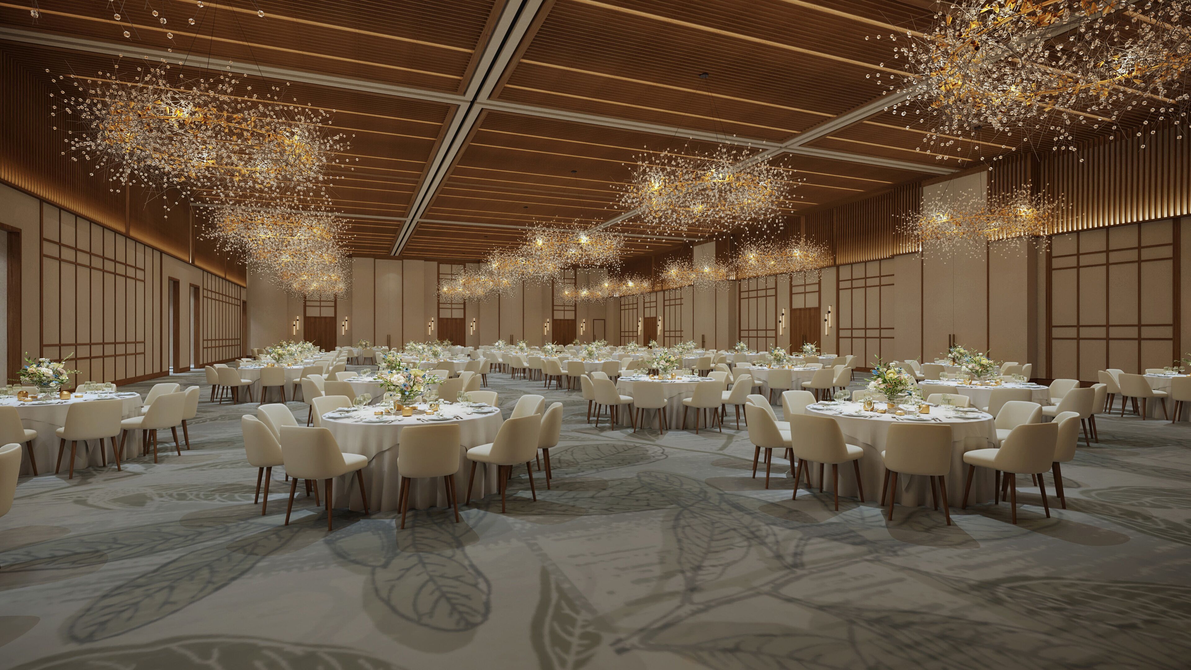 Un amplio salón de banquetes con mesas redondas, sillas blancas y elegantes candelabros.
