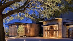 A modern building with a stone facade, large windows, and a well-lit entrance. - Omni PGA Frisco Resort & Spa (Frisco)