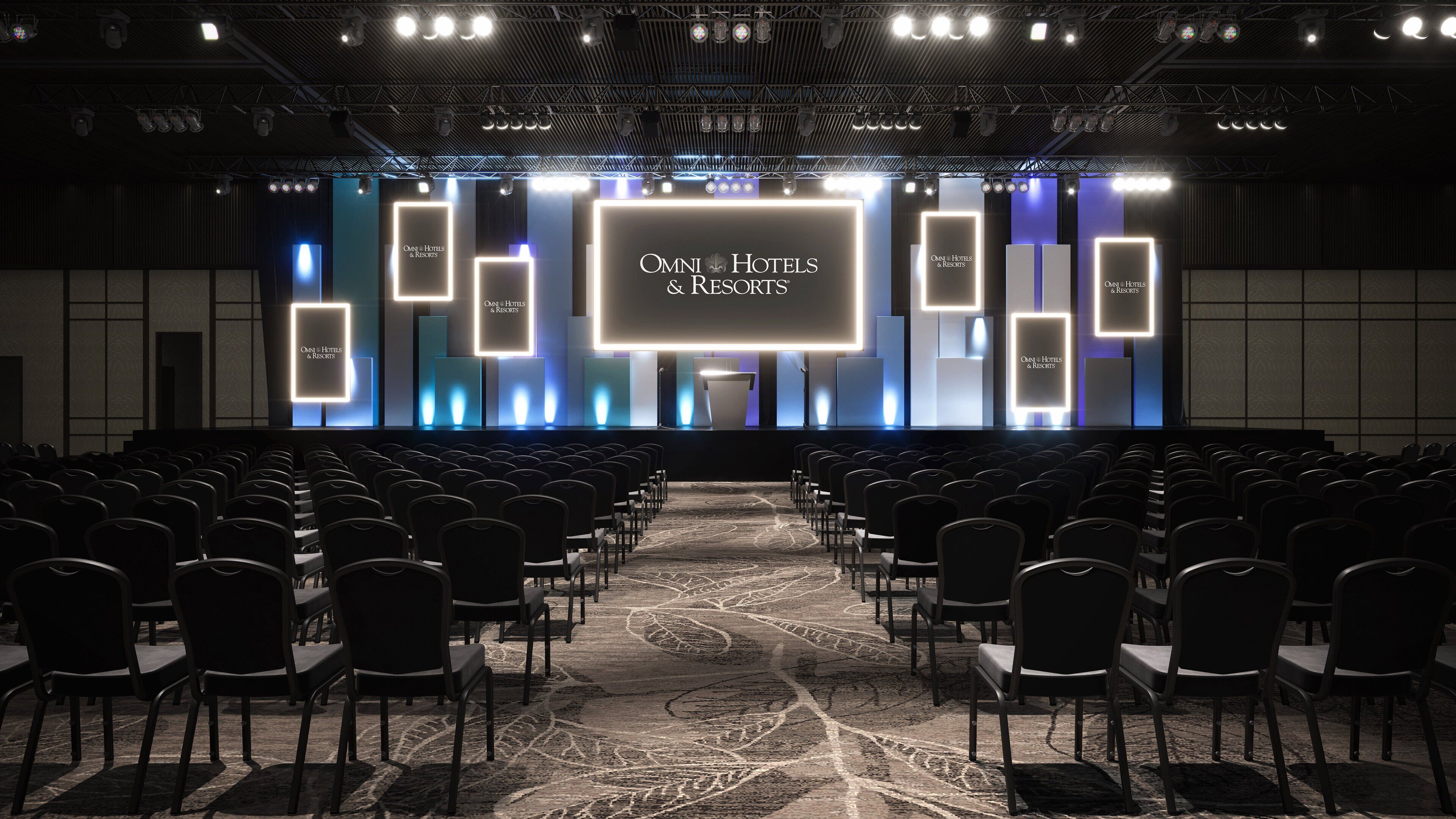 A conference room with rows of chairs facing a stage with a large screen displaying "OMNI Hotels & Resorts".