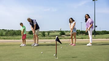 A golf course with players preparing to take a shot.