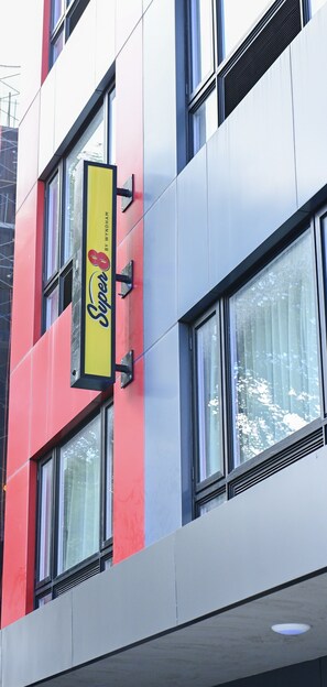 A multi-story building with a prominent sign reading "Super 8 by Wyndham." - Super 8 by Wyndham Bronx Near Botanical Garden (Bronx)