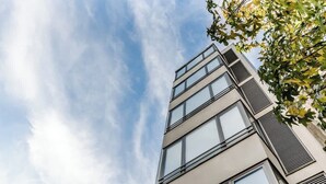 A modern multi-story building with large windows and a flat facade. - Bright Quiet Flat | Terrace by HostWise (Porto)