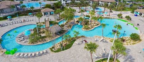 A resort with multiple swimming pools, palm trees, and lounge areas.