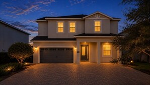 A two-story house with a garage, a driveway, and a well-lit entrance. - 10 Bedrooms/ 10 Bathrooms/ Encore (7709 FD) (Kissimmee)