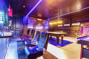 A room with massage chairs, a pool table, and a billiards table.
