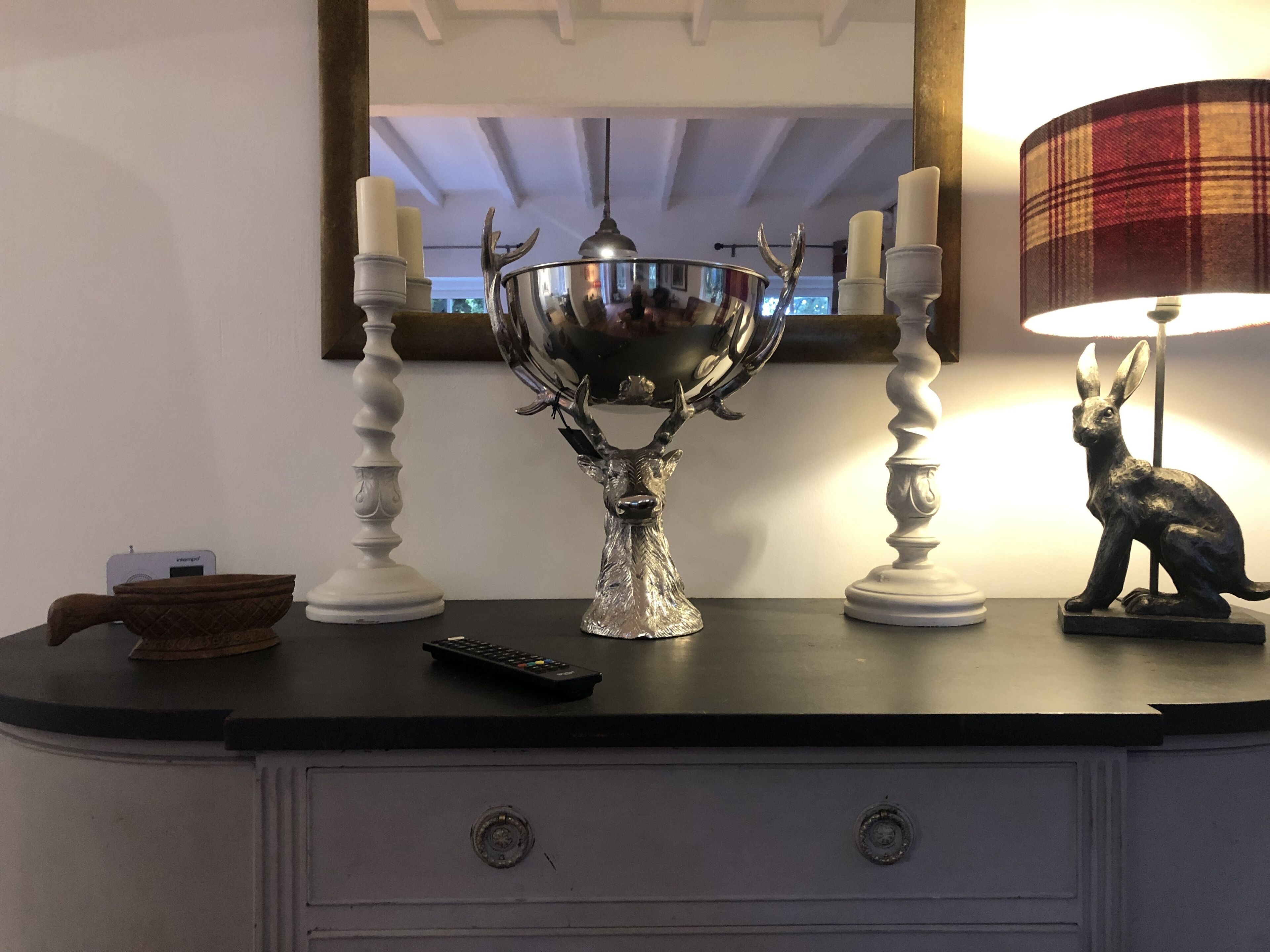 A black countertop with a decorative silver bowl, a remote control, and a small wooden box.