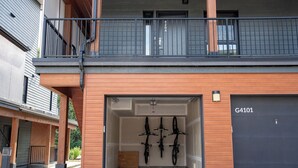 A modern building with a garage door labeled G4101, a wooden facade, and a balcony with a black railing.