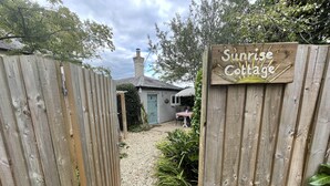 A wooden gate leading to a cottage with a sign reading "Sunrise Cottage." - Stunning 1-bed Cottage With Hot Tub in Ross-on-wye (Ross-on-Wye)