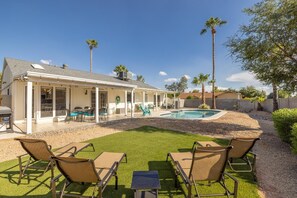 Une maison dotée d’un patio couvert, d’un espace salon extérieur et d’une piscine.
