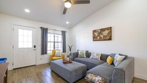 A living room with a grey sofa set, a wooden coffee table, and a world map artwork on the wall. - 4-min to Kierland- Heated Pool & Outdoor Dining, Scottsdale Gem (Scottsdale)