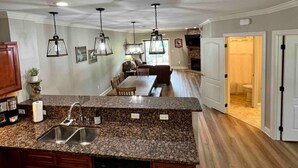 A spacious kitchen with granite countertops, a dishwasher, and wooden cabinets.
