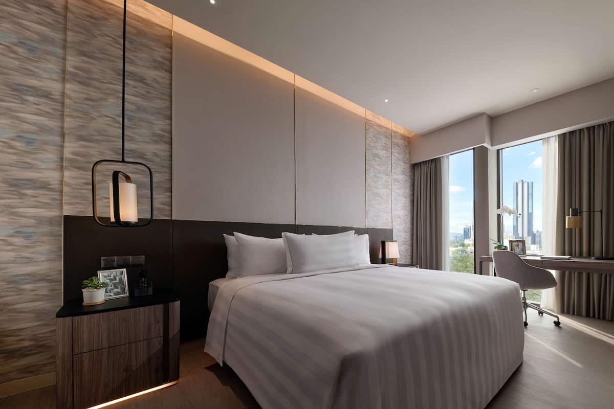 Une chambre d’hôtel moderne avec un grand lit, un bureau et une vue sur la ville.
