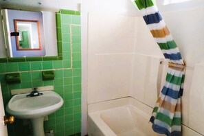 A bathroom with a sink, mirror, and bathtub. - Love Hotels Desert Inn & RV at Boysen Wind River (Shoshoni)