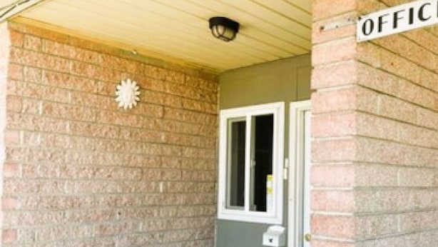 A brick exterior with a sign reading "OFFICE" and a door. - Love Hotels Desert Inn & RV at Boysen Wind River (Shoshoni)