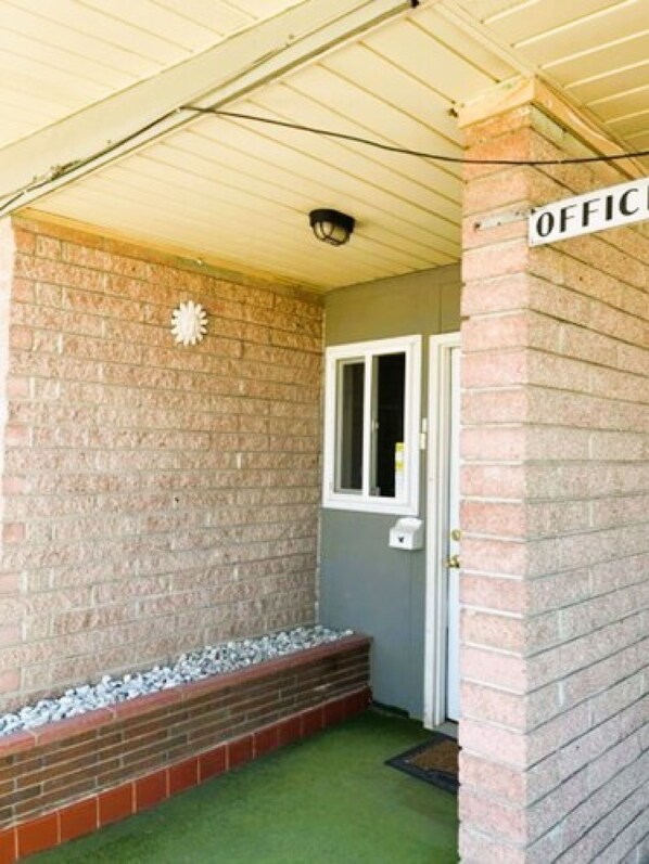 A brick exterior with a sign reading "OFFICE" and a door. - Love Hotels Desert Inn & RV at Boysen Wind River (Shoshoni)
