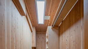 A narrow hallway with wooden walls and a sloped ceiling, leading to a small window. - Oyo Hotel Portland Or Near Airport (Portland)