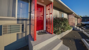 A building with a red door, a small porch, and a parking area. - Oyo Hotel Portland Or Near Airport (Portland)
