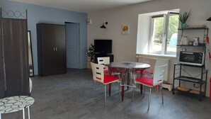 Kompakti keittiö, jossa on ruokapöytä, tuolit, televisio ja ikkuna, josta on näkymä.