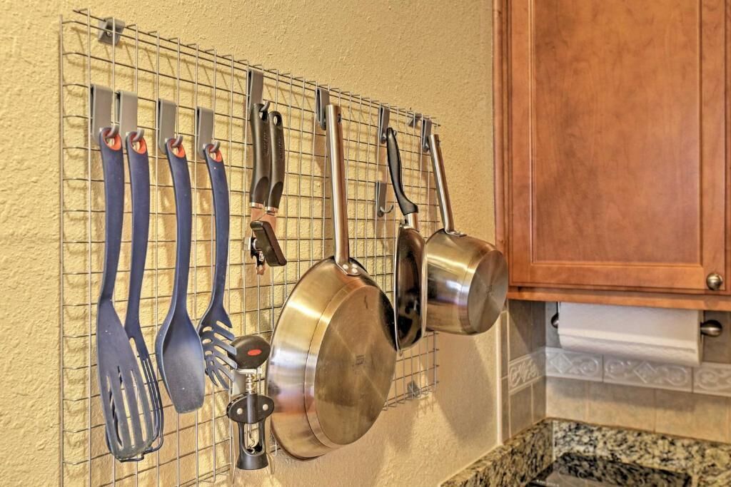 Una cocina con un escurreplatos que contiene varios utensilios y ollas.