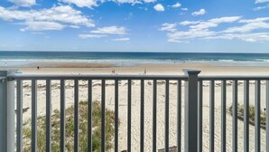 A beach view from a balcony with a railing, sandy beach, and ocean. - Sandcastle (Wells)