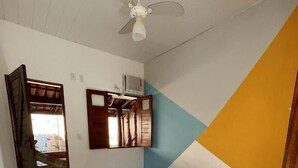 A room with two beds, a ceiling fan, a wooden door, and patterned floor tiles. - Pousada Açuncena (Itacaré)