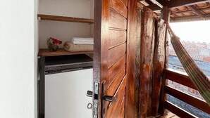 A room with a wooden door, a white cabinet, and a tiled floor. - Pousada Açuncena (Itacaré)