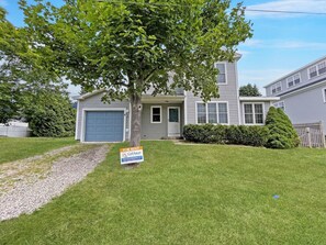 A two-story house with a garage, a lawn, and a 'For Rent' sign.