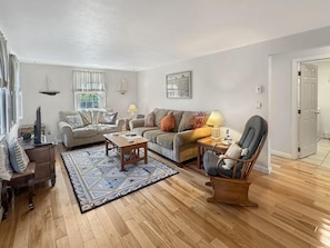 A living room with a sofa, armchair, coffee table, and a patterned rug. - Family Retreat at York Beach (York Beach)