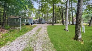 A gravel path leading to a row of cabins in a wooded area. - Dewey Cottage (York Beach)