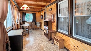A wooden interior with a dining area, large windows, and a wooden bench. - Kurtz Cottage (York Beach)