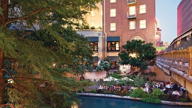 A courtyard with outdoor seating, a pool, and a building with multiple floors and balconies. - Getaway on the Riverwalk @ Riverside Suites- 1 Br Condo (San Antonio)