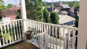A balcony with a potted plant and a table, overlooking a residential area with houses and a church. - The Ivy of Dresden (Dresden)