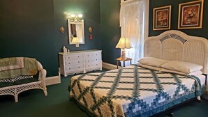 A bedroom with a bed, a dresser, a chair, and two framed pictures on the wall. - The Ivy of Dresden (Dresden)
