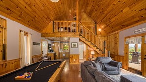A wooden interior with a pool table, a sofa, and a staircase leading to an upper level. - Fall Foliage! - Hot Tub with a View (Sevierville)