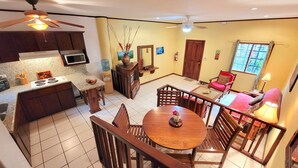 A kitchen with a stove, microwave, and water dispenser. There is a dining area with a table and chairs.
