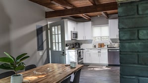 Una cocina moderna con armarios blancos, microondas y lavavajillas.