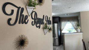 Eine Wand mit dem Schriftzug "The Royal Oak“ und dekorativen Elementen, darunter ein geometrischer Pflanzenbehälter und sternförmige Ornamente.