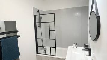 Bathtub, hair dryer, towels, toilet paper