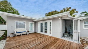 A house with a wooden deck, white exterior, and a covered porch area. - Charming Private 1 BR Suite, Pet Friendly & Minutes to Clearwater Beach! (Clearwater)