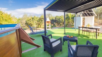 Relax in the shaded patio area with comfortable lounge chairs and a small table.