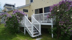 Une maison à deux étages avec un escalier blanc menant à un balcon.