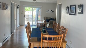 Ruokailutilassa on puinen pöytä ja tuolit, kattotuuletin ja kyltti, jossa lukee: ”Lake House”.