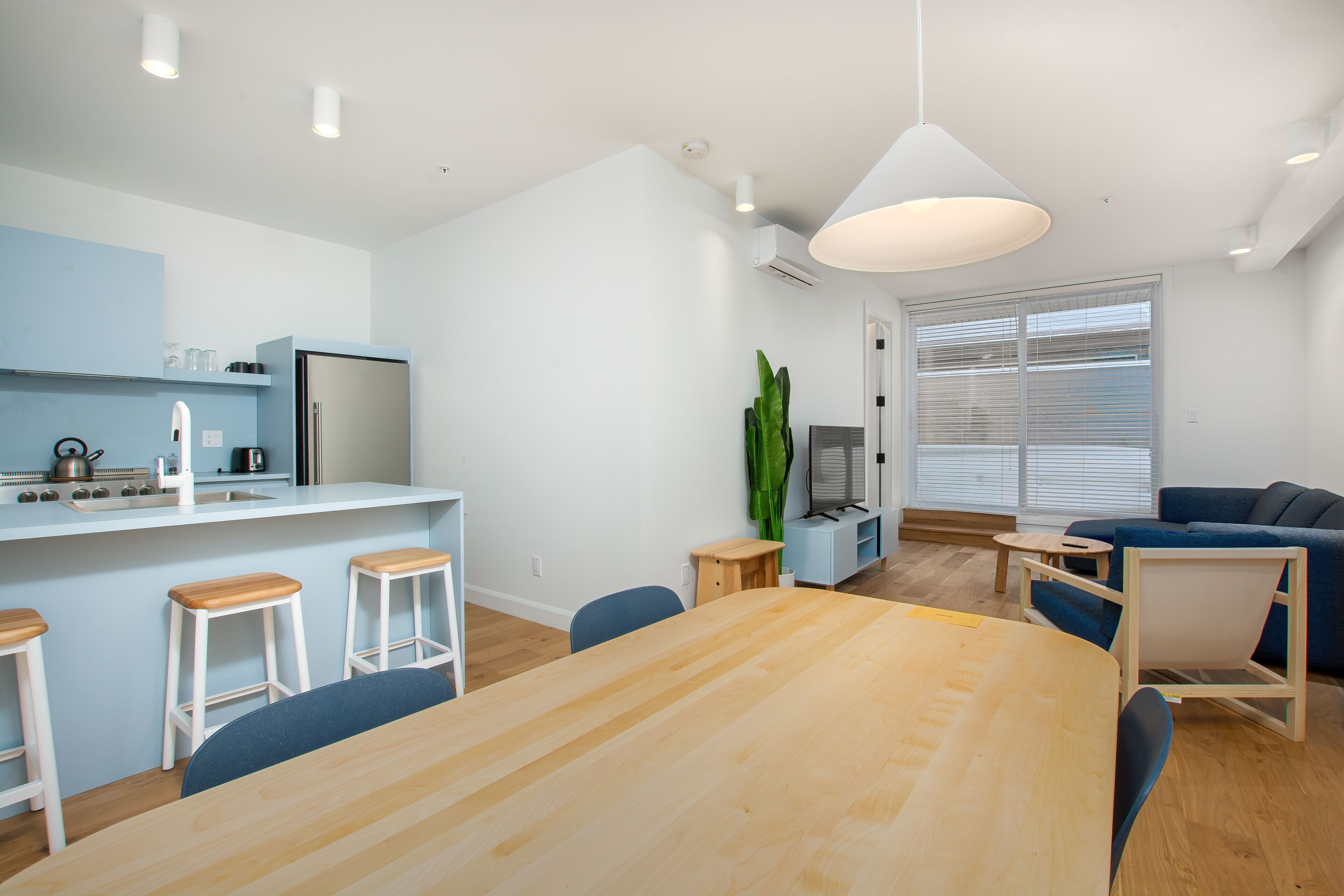 A modern living space with a kitchen, dining area, and seating area.